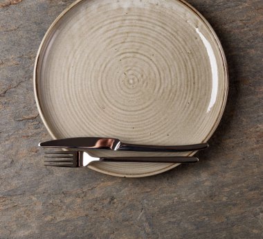 Masa ayarı. Taş zeminde tabak, bıçak ve çatal.