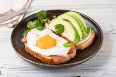 Tahta bir masada kızarmış yumurtalı tost.
