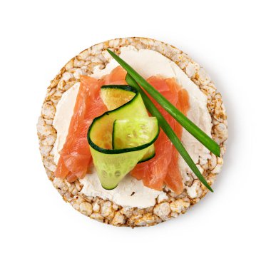 Krem peynirli pirinç kekleri, somon balığı ve beyaz arka planda izole edilmiş salatalık üst görünümü.