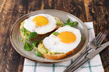 Tahta bir masada kızarmış yumurtalı tost.