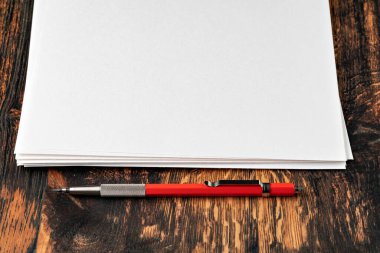 Tahta masanın üzerinde mekanik kalemle boş bir kağıt.