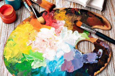 Renkli boya ve fırçayla boyanmış sanat paleti.