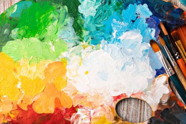 Renkli boya ve fırçayla boyanmış sanat paleti.