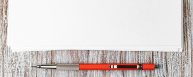 Tahta masanın üzerinde mekanik kalemle boş bir kağıt.