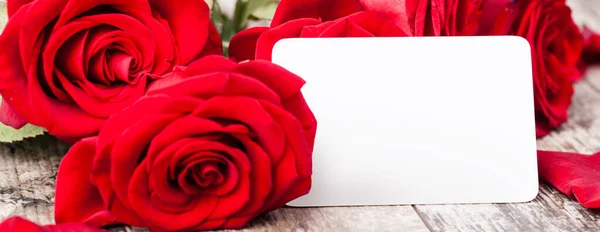 Rote Rosen Mit Einem Leeren Geschenkanhänger Auf Einem Waldboden — Stockfoto