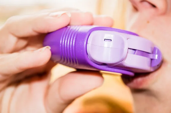 Young woman using asthma inhaler — Stock Photo, Image