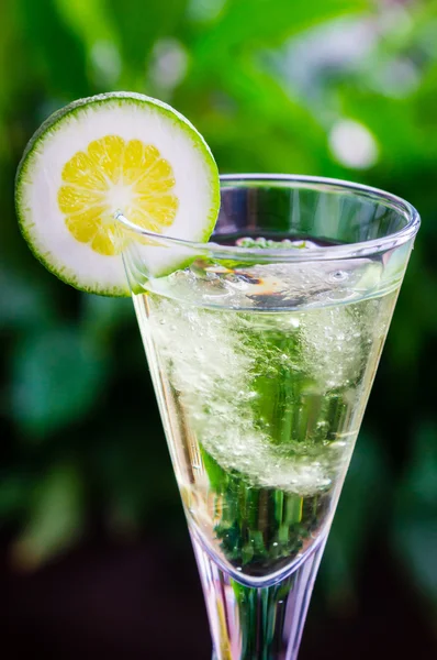 Yellow cocktail with a slice of lime — Stock Photo, Image