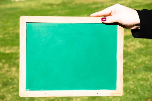 Woman holding a green chalkboard — Stock Photo, Image