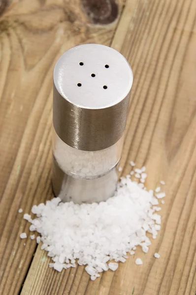 Saltshaker with Salt on wood — Stock Photo, Image