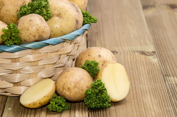 Свежая картошка и петрушка в корзине — стоковое фото