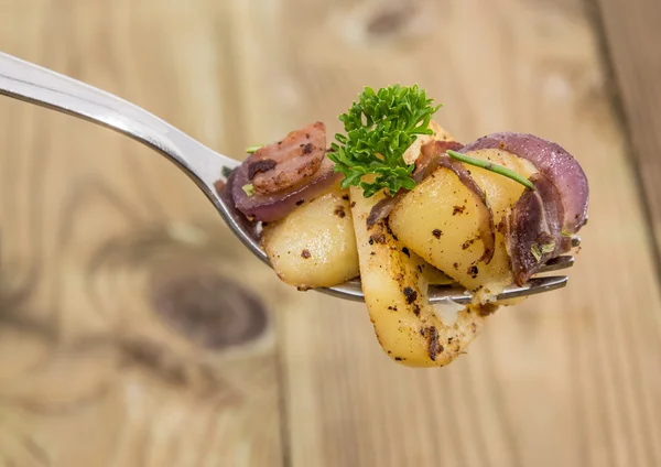 Fork with fried Potatoes on wood — Stock Photo, Image