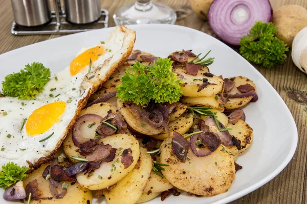 Fried Egg on a heap of roasted Potatoes — Stock Photo, Image