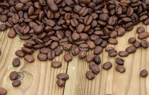 Houten tafel met koffiebonen — Stockfoto