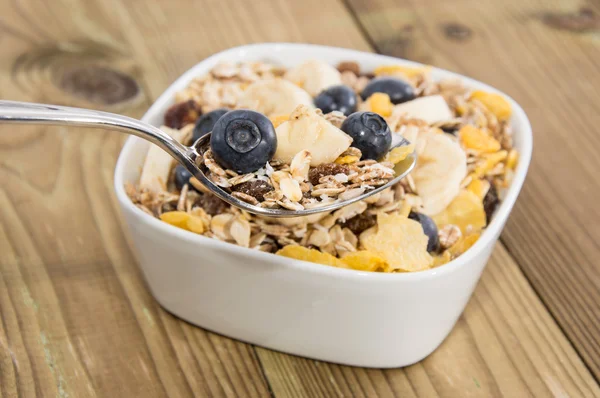 Muesli on a spoon with bowl in background — Stock Photo, Image