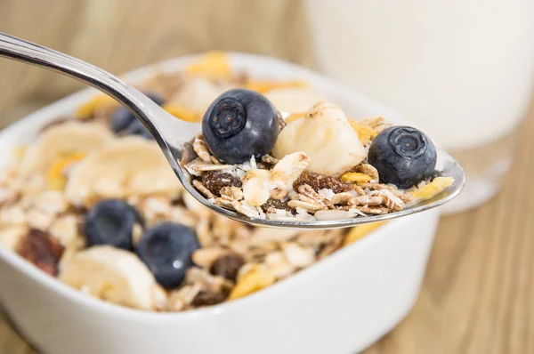 Muesli on a spoon with bowl in background — Stock Photo, Image
