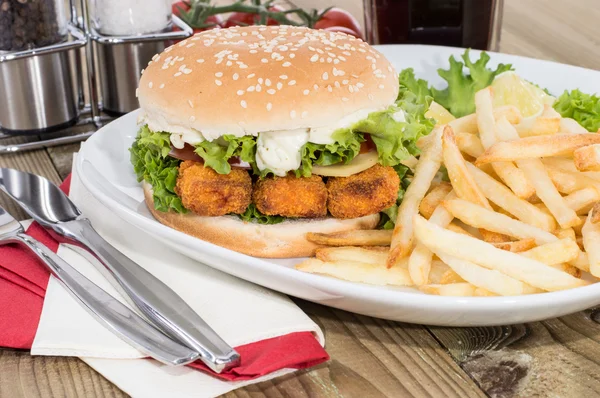 Hamburguesa de pescado con patatas fritas en un plato —  Fotos de Stock