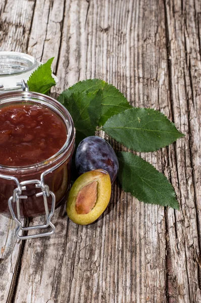 Glass with Plum Jam on wood — Stock Photo, Image