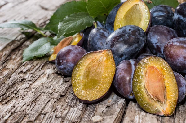 Heap of fresh Plums with leaves — Zdjęcie stockowe