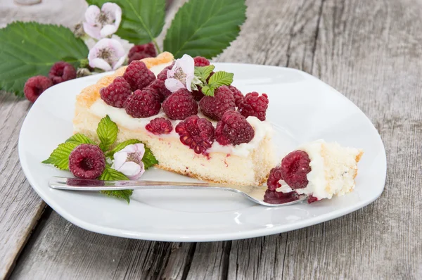 Tarta sobre un plato sobre fondo de madera — Foto de Stock