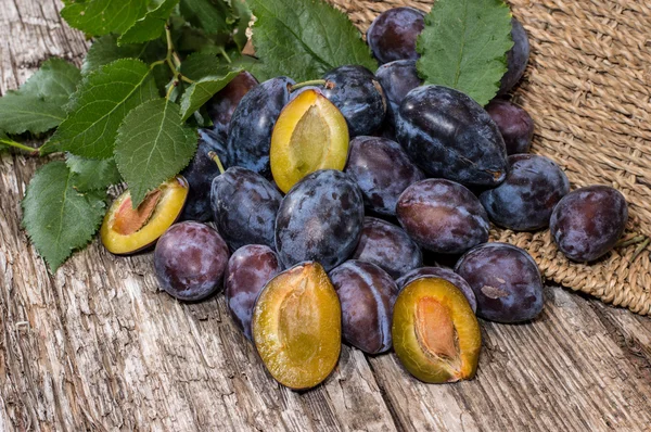 Heap of fresh Plums with leaves — Stock Photo, Image