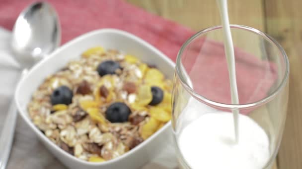 Verter leche en un vaso (con Muesli en el fondo) ) — Vídeos de Stock