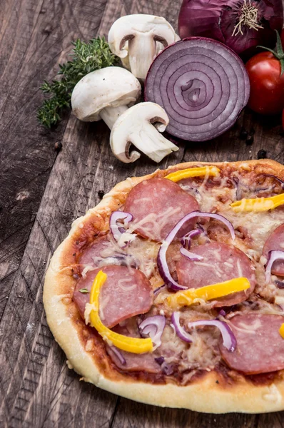 Salami pizza op hout — Stockfoto