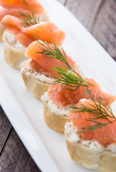 Baguette with Salmon on wood — Stock Photo, Image