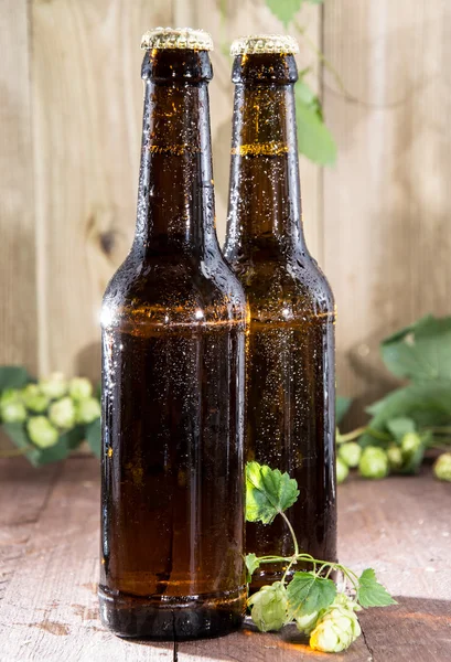 Dos botellas mojadas de cerveza sobre madera — Foto de Stock
