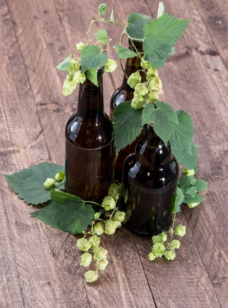 Bottle of Beer with Hops on wood — Stock Photo, Image