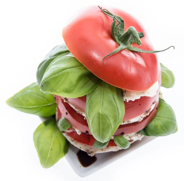 Geschichtete Tomaten- und Mozzarella-Scheiben auf weiß — Stockfoto