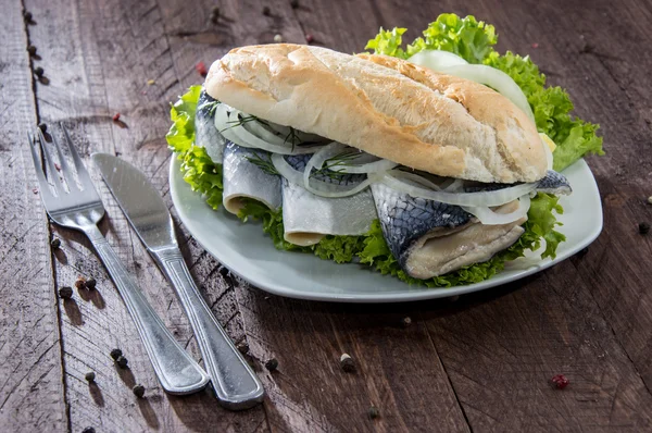 Sandwich de peixe no fundo de madeira — Fotografia de Stock