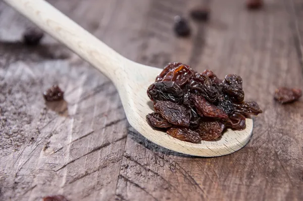 Raisins on a wooden spoon — Stock Photo, Image