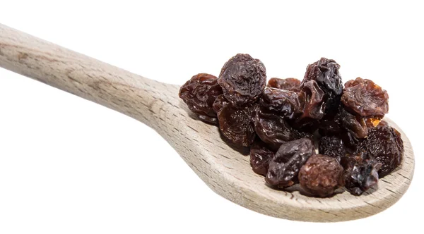 Raisins on a wooden spoon against white — Stock Photo, Image