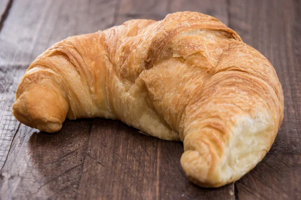 Croissant on wooden background — Stock Photo, Image