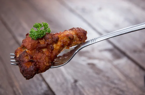 Kyckling vinge på en gaffel (trä bakgrund) — Stockfoto