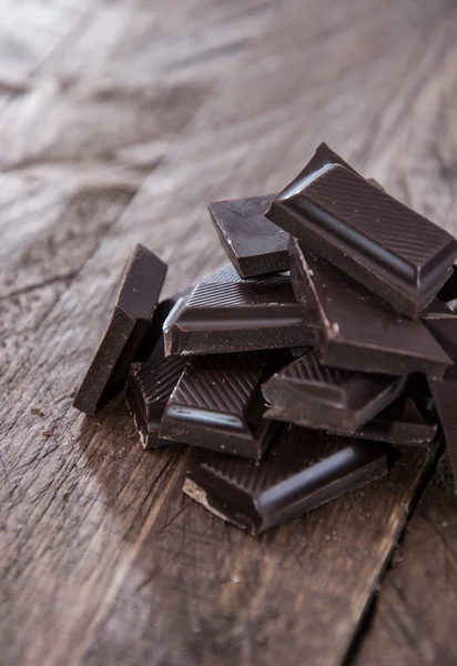 Haufen Schokolade auf Holz — Stockfoto