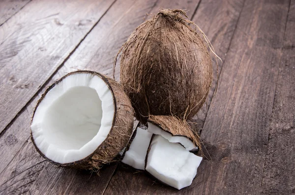 Gebarsten kokosnoot op hout — Stockfoto
