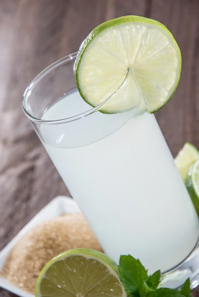 Limettensaft auf Holz — Stockfoto