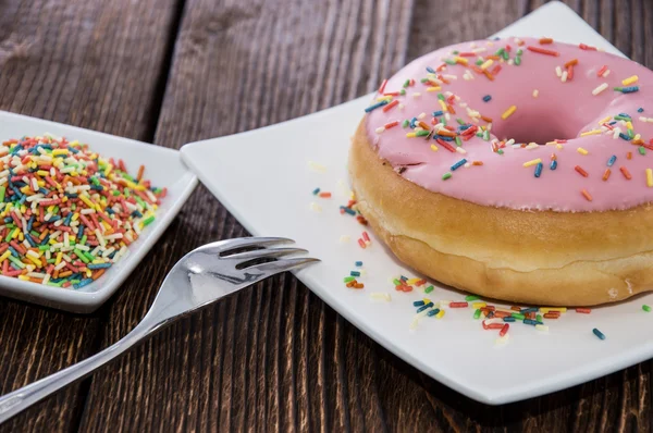 Enda rosa donut på en tallrik — Stockfoto