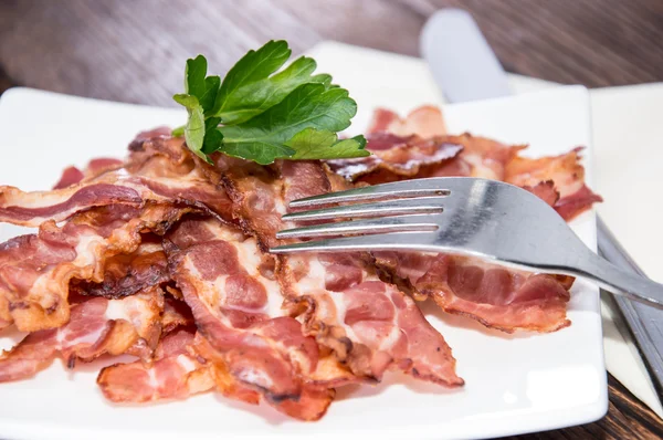 Tas de bacon frit sur une assiette — Photo