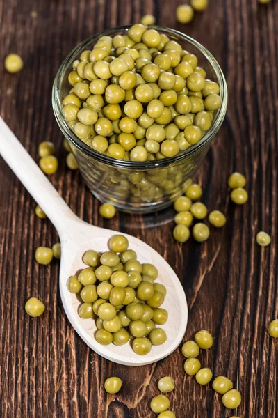 Peas on a wooden spoon — Stock Photo, Image