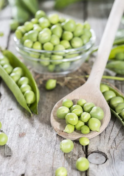 Frische Erbsen auf einem Kochlöffel — Stockfoto