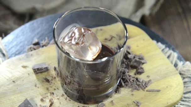 Licor de chocolate con hielo en un vaso — Vídeo de stock