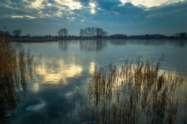 Donmuş bir göl üzerindeki gökyüzünün yansıması, Stankow, Polonya