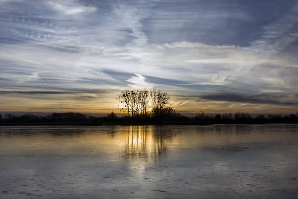 Reflexão do pôr do sol em um lago congelado, noite de janeiro — Fotografia de Stock