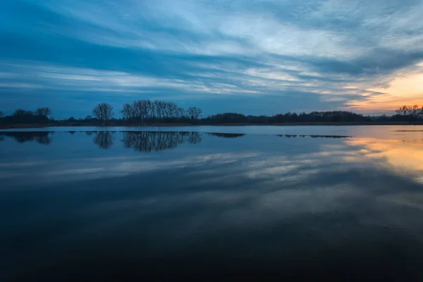 Reflexão das nuvens noturnas em um lago calmo — Fotografia de Stock