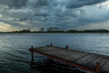 Gölün üzerindeki yaya köprüsü ve bulutlu gökyüzü, Stankow, Polonya