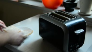 Elektrikli tost makinesine tost koyan bir adam.
