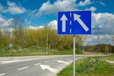 Mavi dikdörtgen yol işareti ve beyaz oklar