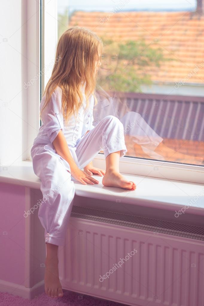 Little girl sitting near the window